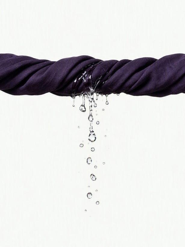 Twisted dark fabric with water dripping from it